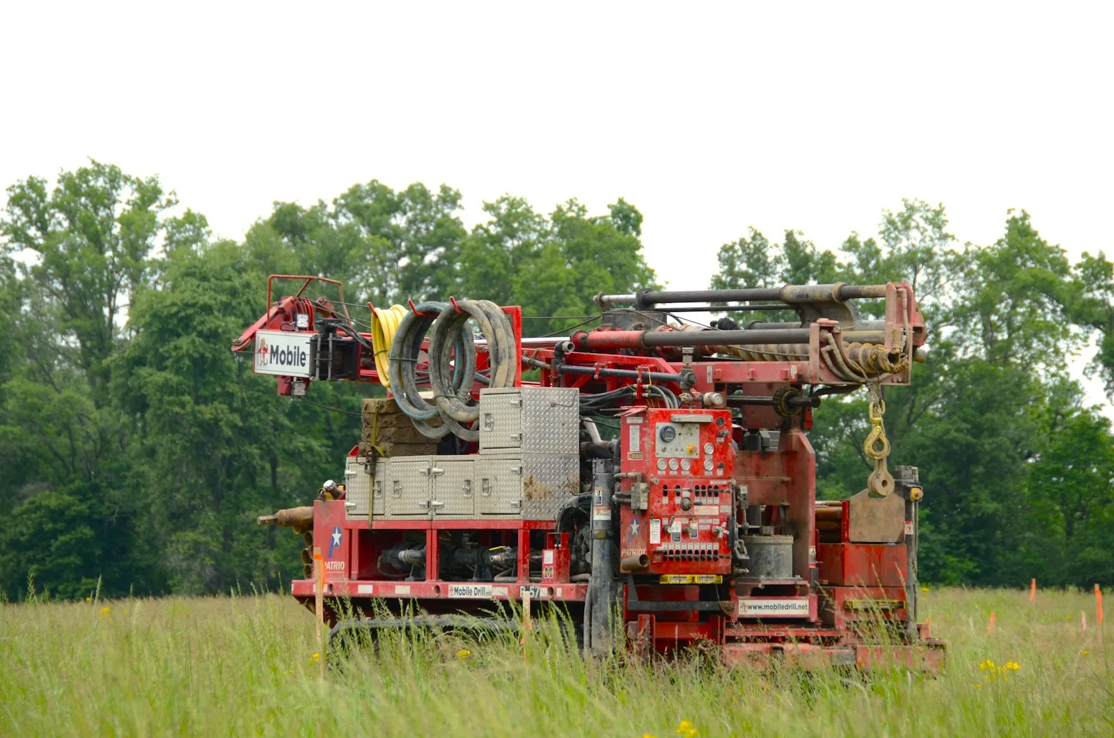 Track rig drilling geothermal boreholes in a field