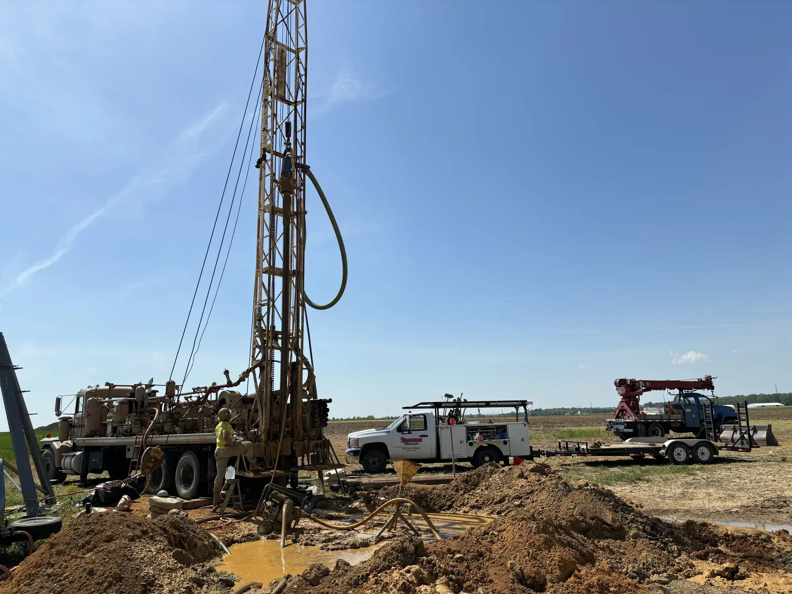 D.N. Drilling rig and service trucks drilling a water well in a South Jersey field